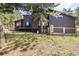 Rear exterior view highlighting a deck, dark siding, and beautiful treed landscaping at 37 Wagner Cir, Boulder, CO 80304