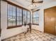 Cozy breakfast nook with large windows and tile flooring, adjacent to an entry door at 10443 W 84Th Pl, Arvada, CO 80005