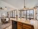 Bright kitchen featuring a large sink, wooden trim windows, and dining area at 10443 W 84Th Pl, Arvada, CO 80005