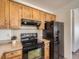 Kitchen showcasing wood cabinets, modern black appliances, and ample counter space at 10443 W 84Th Pl, Arvada, CO 80005