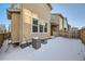 Backyard view of house with AC unit and snowy ground at 677 Brookwood Dr, Lafayette, CO 80026