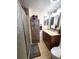 Well-maintained bathroom with a glass-enclosed shower, storage cabinet and vanity at 13474 W 65Th Dr, Arvada, CO 80004