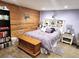 Charming bedroom featuring a wood accent wall, stylish decor, and a comfortable, inviting atmosphere at 13474 W 65Th Dr, Arvada, CO 80004
