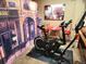 Exercise area featuring a stationary bike, Coca-Cola table and chairs, and Paris themed wall art at 13474 W 65Th Dr, Arvada, CO 80004