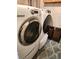 Modern laundry room with front-load washer and dryer, complemented by a patterned rug at 13474 W 65Th Dr, Arvada, CO 80004