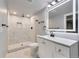 Modern bathroom with an updated vanity, rainfall shower head, and black hardware at 1705 S Yuma St, Denver, CO 80223