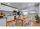 An open-concept kitchen features white cabinets, stainless steel appliances, and an inviting dining area at 1705 S Yuma St, Denver, CO 80223