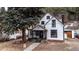 Charming white house with black accents and a spacious front porch at 408 Soda Creek Rd, Idaho Springs, CO 80452
