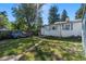 Large, sunny backyard featuring green grass and a covered vehicle at 2862 S Grant St, Englewood, CO 80113