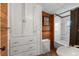 Bathroom featuring wood paneled walls, shower over tub with curtains, sink, and built-in storage at 2862 S Grant St, Englewood, CO 80113