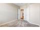 Open bedroom with neutral walls and carpet, showcasing two doors and an opening to the rest of the home at 5705 N Genoa Way # 206, Aurora, CO 80019