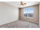 Bright, empty bedroom with gray carpet, a large window with a neighborhood view, and ample wall space at 5705 N Genoa Way # 206, Aurora, CO 80019
