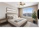 Bright bedroom featuring a large window, ceiling fan, and neutral decor with a large comfortable bed and ample space at 5705 N Genoa Way # 206, Aurora, CO 80019