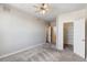 Bright, spacious bedroom with an open closet, overhead fan, and gray carpeting at 5705 N Genoa Way # 206, Aurora, CO 80019