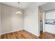 A cozy dining room with wood floors, a modern light fixture, and an open doorway leading to the kitchen at 5705 N Genoa Way # 206, Aurora, CO 80019