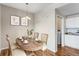 This dining room features a wood table set for four with a hanging chandelier, opening to the kitchen at 5705 N Genoa Way # 206, Aurora, CO 80019