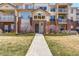 Inviting entrance to a well-maintained building with manicured lawn and visible unit numbers at 5705 N Genoa Way # 206, Aurora, CO 80019