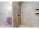 Walk-in shower featuring stone tile, a mounted shower head and an adjustable handheld shower head at 5705 N Genoa Way # 206, Aurora, CO 80019