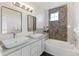 Elegant bathroom with double sinks, soaking tub, and a mosaic tile accent wall at 16058 E Geddes Ln # 26, Aurora, CO 80016