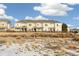 Tan townhouses with wooden fences and snowy ground in the front at 16058 E Geddes Ln # 26, Aurora, CO 80016