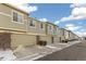 Tan colored townhouses with attached garages and snow on the ground at 16058 E Geddes Ln # 26, Aurora, CO 80016