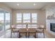 Bright dining room with large windows, modern table, and beautiful stone fireplace at 3008 Blithe Pt, Castle Rock, CO 80108