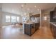 Large kitchen island with pendant lighting open to dining area with lots of natural light at 3008 Blithe Pt, Castle Rock, CO 80108