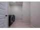 Functional laundry room with modern washer and dryer, tile flooring, and ample space at 3008 Blithe Pt, Castle Rock, CO 80108