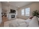 Cozy living room featuring stone fireplace, large windows, and comfortable sectional sofa at 3008 Blithe Pt, Castle Rock, CO 80108