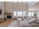 Bright and airy living room with a cozy fireplace, large windows, and an open-concept design at 3008 Blithe Pt, Castle Rock, CO 80108
