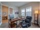 Comfortable home office with a large desk, ergonomic chair, and ample natural light at 3008 Blithe Pt, Castle Rock, CO 80108