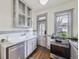 Bright kitchen featuring stainless steel appliances, farmhouse sink, wood floors, and a charming vintage design at 1475 Saint Paul St, Denver, CO 80206