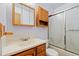 Bathroom with wooden vanity, medicine cabinet, and shower-tub combo at 9844 Fairwood St, Littleton, CO 80125