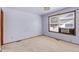 Simple bedroom featuring neutral carpet, a window, and a wall-mounted air conditioning unit at 9844 Fairwood St, Littleton, CO 80125