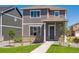 Two-story home with stone accents, gray siding, a well-manicured lawn and walkway to the front door at 28630 E 8Th St, Watkins, CO 80137