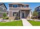 Two-story home with stone accents, gray siding, a well-manicured lawn and walkway to the front door at 28630 E 8Th St, Watkins, CO 80137
