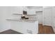 The kitchen boasts stainless steel appliances, granite countertops, white cabinetry, and hardwood flooring at 28630 E 8Th St, Watkins, CO 80137