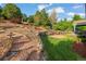 Beautifully landscaped backyard features tiered garden beds, mature trees, and a cozy patio space at 23327 E Ottawa Dr, Aurora, CO 80016