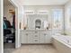 Bright bathroom with double sink vanity, soaking tub, and walk-in closet for storage at 23327 E Ottawa Dr, Aurora, CO 80016