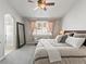 Comfortable bedroom with a ceiling fan, a window, a bench, and a doorway into the bathroom at 23327 E Ottawa Dr, Aurora, CO 80016