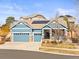 Charming blue home with a three-car garage, stone accents, and solar panels on the roof at 23327 E Ottawa Dr, Aurora, CO 80016