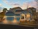 Charming blue home with a three-car garage, stone accents, and solar panels on the roof at 23327 E Ottawa Dr, Aurora, CO 80016