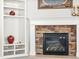 Charming living room featuring a brick fireplace with a white mantle and adjacent built-in bookshelves at 23327 E Ottawa Dr, Aurora, CO 80016