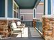 Inviting covered front porch featuring stone pillars and comfortable outdoor seating at 23327 E Ottawa Dr, Aurora, CO 80016