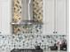 Close-up of stainless vent hood and designer backsplash in the kitchen area at 23327 E Ottawa Dr, Aurora, CO 80016