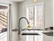 Close-up of a modern kitchen sink and countertop with natural light from the window at 23327 E Ottawa Dr, Aurora, CO 80016