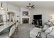 An open-concept living room with a stone fireplace, modern lighting, and an open layout to the kitchen at 23327 E Ottawa Dr, Aurora, CO 80016