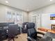 Home office featuring dark wood desks, leather chairs, plantation shutters, and views to the outside at 23327 E Ottawa Dr, Aurora, CO 80016