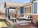 The covered patio has stone floors, plenty of seating and a view of the backyard at 23327 E Ottawa Dr, Aurora, CO 80016