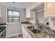 Kitchen featuring granite countertops, stainless steel sink, and white cabinetry at 9867 E Peakview Ave # E1, Englewood, CO 80111